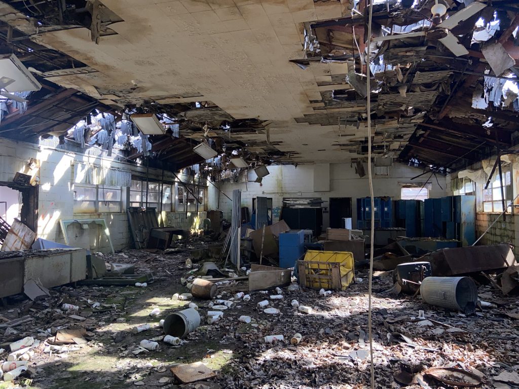Knight Hospital interior with ceiling holes and debris, 2022