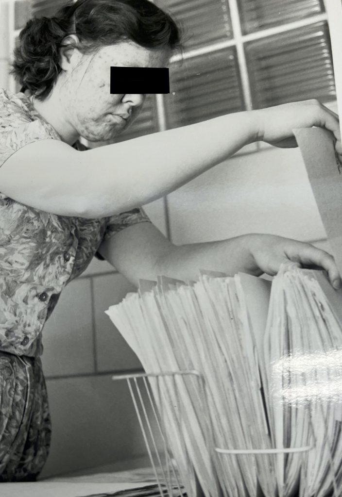 Same person continuing to organize papers in a filing basket