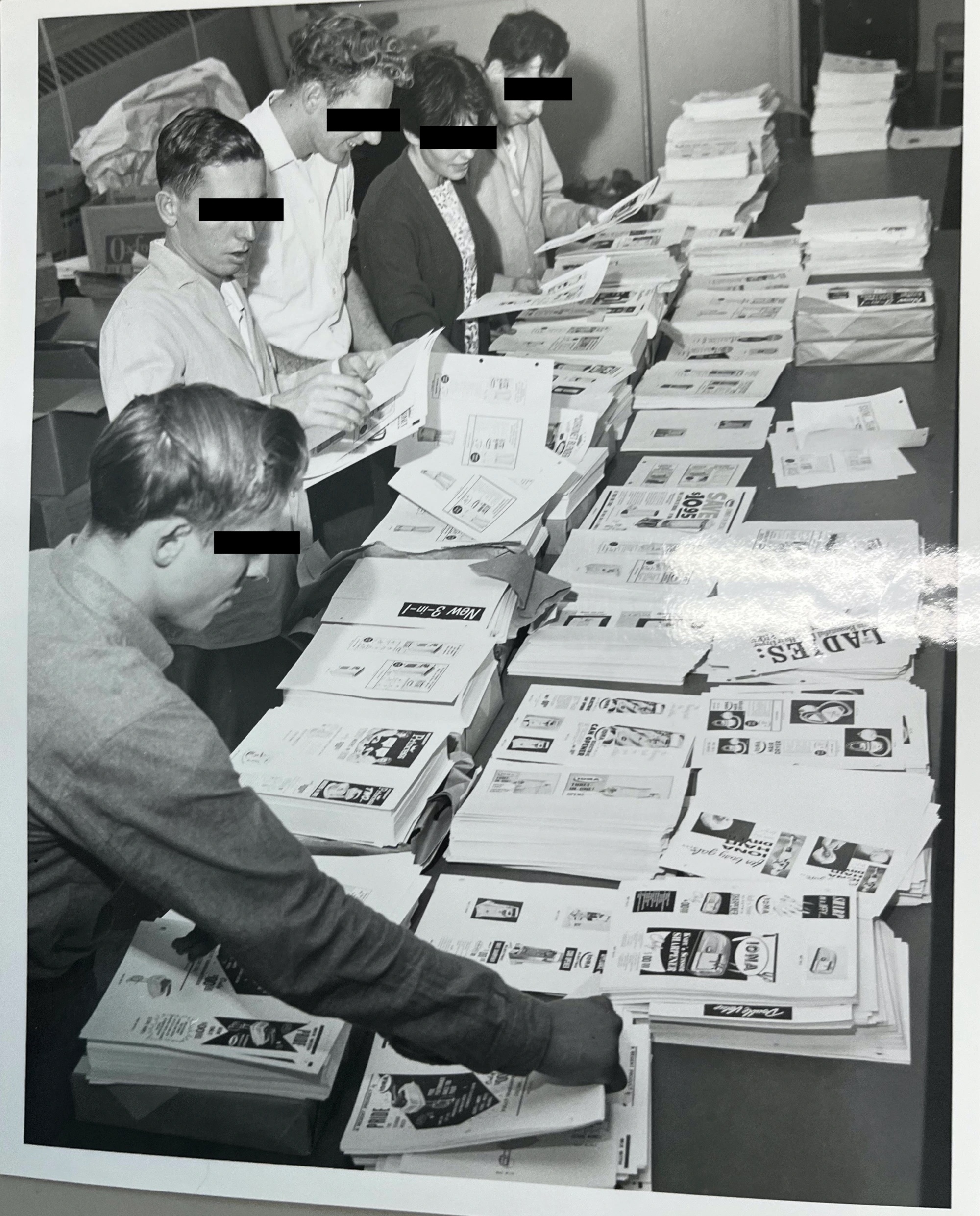 Five residents standing in a line around a table covered with newspaper