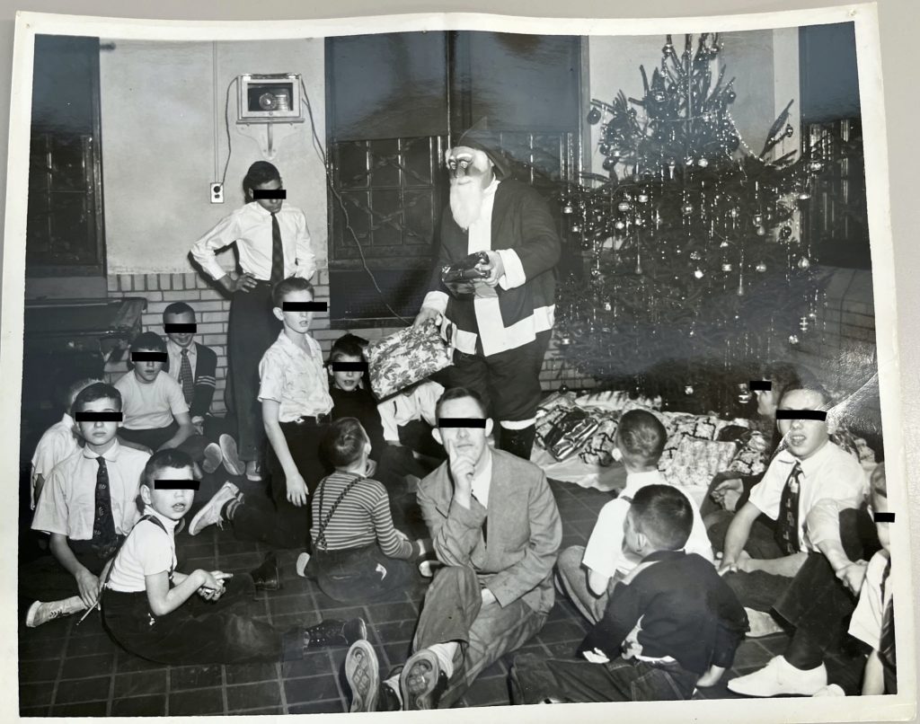 Man dressed as Santa Claus wearing a plastic mask