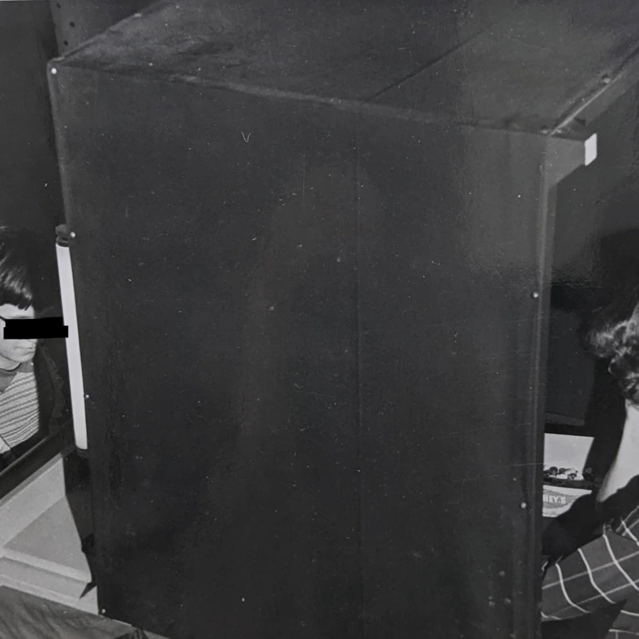 Research staff member and child seated in a black boothip