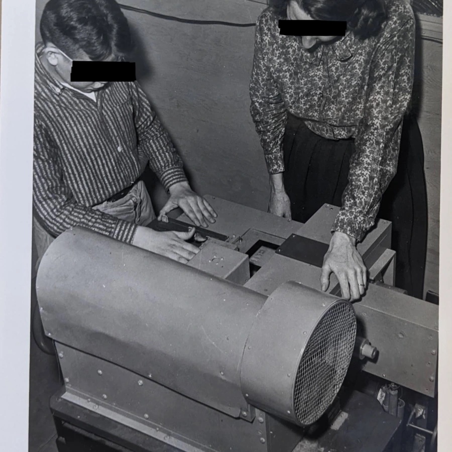 Researcher and young child standing in front of an unidentified machine