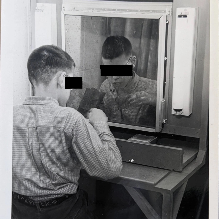 Young Mansfield Training School resident seated a two-way mirror