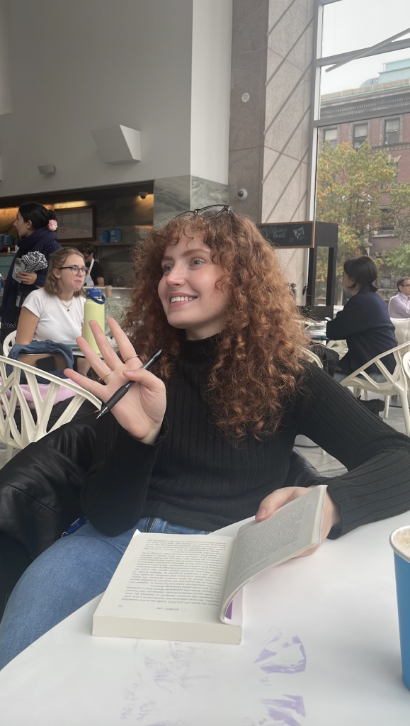 Jess Gallagher, at a coffee shop smiling