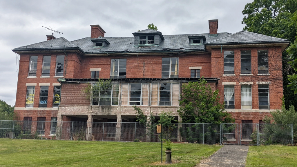 Abandoned brick building with broken windows from the Mansfield Training School era